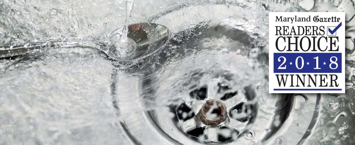 Photograph of water splashing down kitchen sink drain